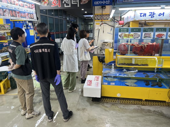 In an undated photo released by the Seoul Metropolitan Government on Monday, city government officials collect seafood samples and conduct safety inspections at a fish market in Seoul. [SEOUL METROPOLITAN GOVERNMENT]