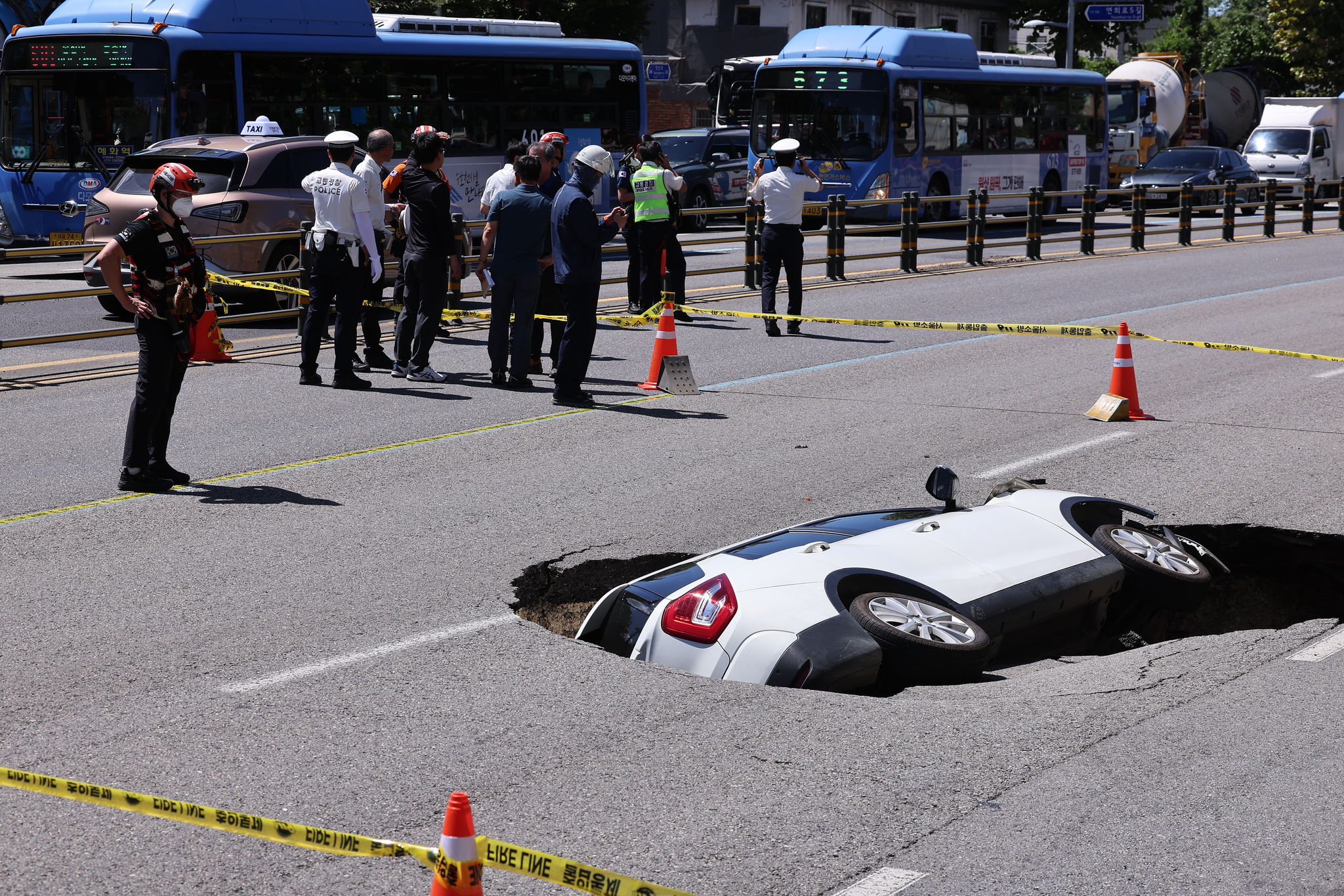 First responders control the site where a sinkhole appeared in Yeonhui-dong, western Seoul, last Thursday. [YONHAP] 