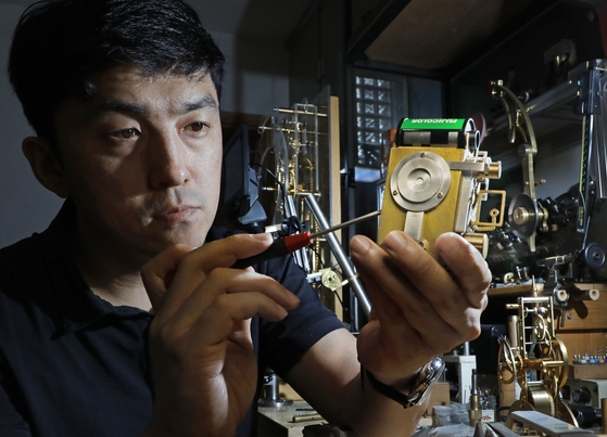 Metal artist Hyun Kwang-hun focuses on assembling a pinhole camera at his studio located in Huam-dong, Yongsan District, central Seoul.  [PARK SANG-MOON] 