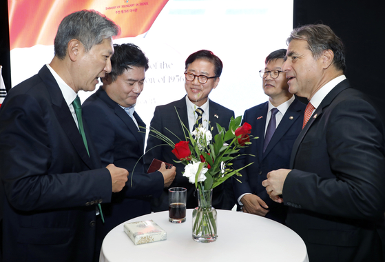 Dignitaries including Ryu Kwon-ha, center, honorary consul of Hungary and a visiting professor at Jeonbuk National University, chat during a national day event commemorating the Hungarian Revolution of 1956 at the Ambassador hotel in central Seoul on Friday. [PARK SANG-MOON]
