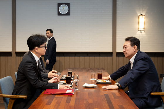 People Power Party leader Han Dong-hoon, left, and President Yoon Suk Yeol, right, speak over tea at the Pine Grass reception hall of the presidential complex in Yongsan District, central Seoul, on Monday afternoon. [PRESIDENTIAL OFFICE]