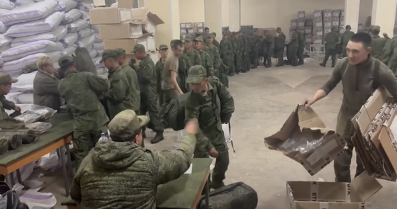 Soldiers believed to be from North Korea are standing in line to receive supplies from Russia on Oct. 19 in a screen capture of video footage released by the Ukrainian Center for Strategic Communication and Information Security, or Spravdi, Friday, on Facebook. [SCREEN CAPTURE]