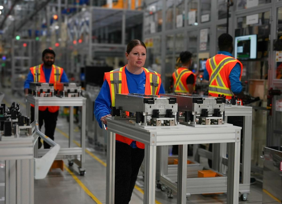 Workers carry components at NextStar Energy's battery plant in Ontario, Canada. [YONHAP]
