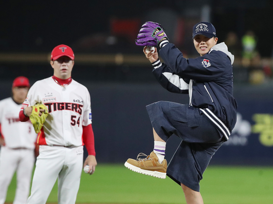BTS member J-Hope, right, throws out the ceremonial first pitch before Game 2 of the Korean Series between the Kia Tigers and Samsung Lions at Gwangju-Kia Champions Field in Gwangju. [NEWS1]