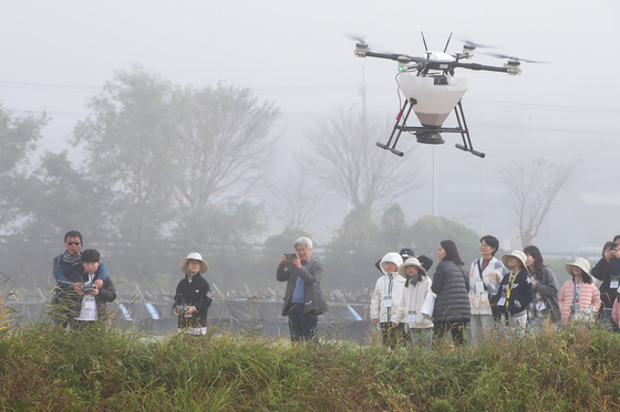 Members of the KT DMZ Ecological Conservation Group use drones to feed migratory birds on Thursday. [KT]