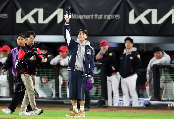 BTS member J-Hope waves to the crowd after throwing out the ceremonial first pitch before Game 2 of the Korean Series between the Kia Tigers and Samsung Lions at Gwangju-Kia Champions Field in Gwangju. [NEWS1]
