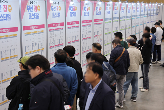 Job seekers look at postings at the 2024 Busan Job Festival. [YONHAP]