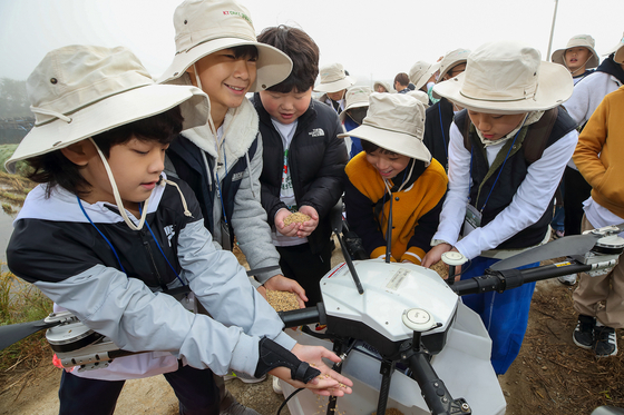 Members of the KT DMZ Ecological Conservation Group use drones to feed migratory birds on Thursday. [KT]