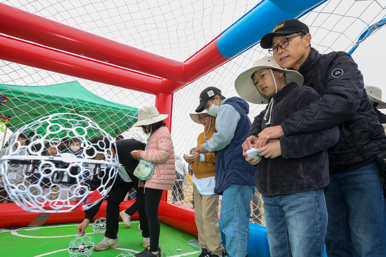 Members of the KT DMZ Ecological Conservation Group use drones to feed migratory birds on Thursday. [KT]