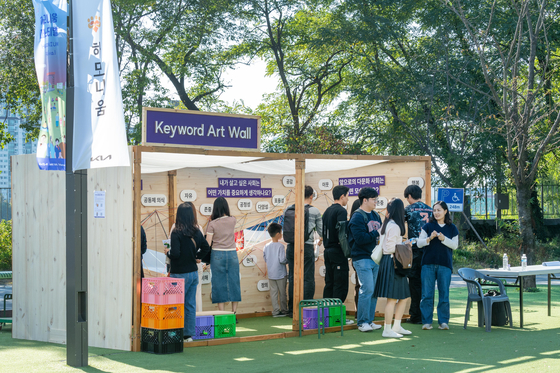Attendees experience the "Keyword Art Wall" at Kia's Harmonium Festival on Nodeul Island in Yongsan District, central Seoul. [YONHAP]