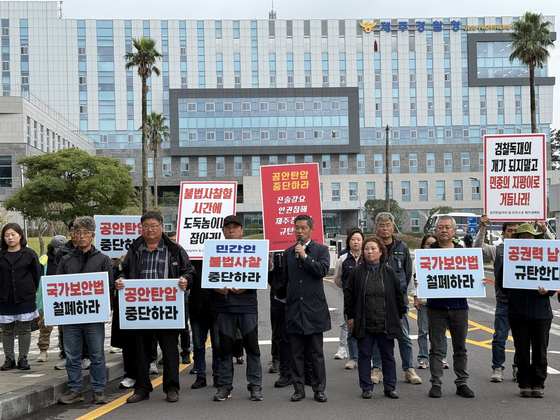 Left-leaning civic activists hold placards calling on the South Korean government to “cease illegal surveillance of civilians” and “abolish the National Security Act” during a protest in front of the headquarters of the Jeju Special Self-Governing Provincial Police Agency on Monday. [YONHAP]