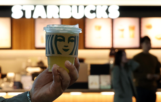 A Starbucks iced drink is pictured in front of a Starbucks store in Seoul on Monday. [YONHAP] 