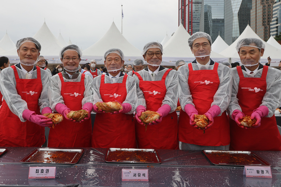 Executives and Yeongdeungpo District officials pose with the kimchi they made for donation. [YONHAP]