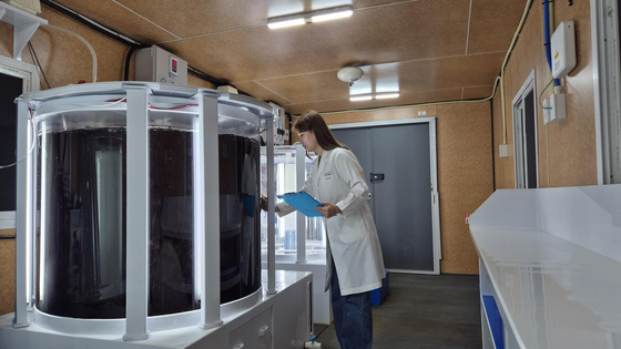 A Pulmuone researcher examines seaweed in a tank where it is farmed. [PULMUONE]