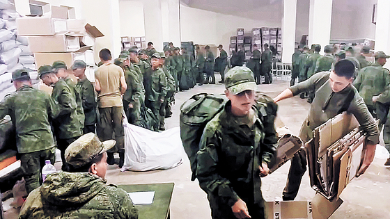 Soldiers believed to be from North Korea are standing in line to receive Russian military supplies on Oct. 19 in a screen capture of video footage released by the Ukrainian Center for Strategic Communication and Information Security, also known as Spravdi. [SCREEN CAPTURE]