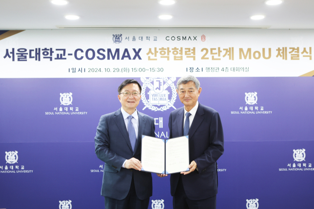 Seoul National University President Ryu Hong-lim, left, poses for a photo with Cosmax Chairman Lee Kyung-soo after signing a memorandum of understanding to continue cosmetics technology research. [SEOUL NATIONAL UNIVERSITY]