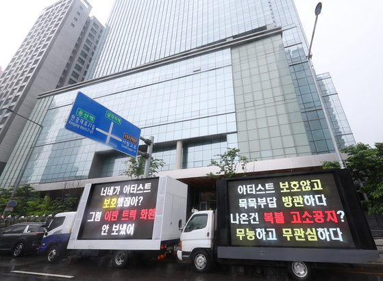 Trucks showing messges from fans stand in front of HYBE headquarters in Yongsan District, central Seoul in May. [YONHAP]