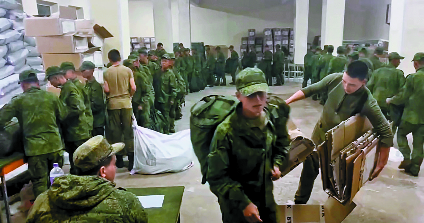Soldiers believed to be from North Korea stand in line to receive Russian military supplies on Oct. 18 in a screen capture of video footage released by the Ukrainian Center for Strategic Communication and Information Security, also known as Spravdi. [SCREEN CAPTURE]