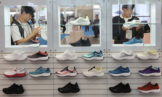 Visitors view slip-on sneakers at the 2024 Busan International Footwear, Textile and Fashion Exhibition at the Bexco convention center in Busan on Thursday. [YONHAP]