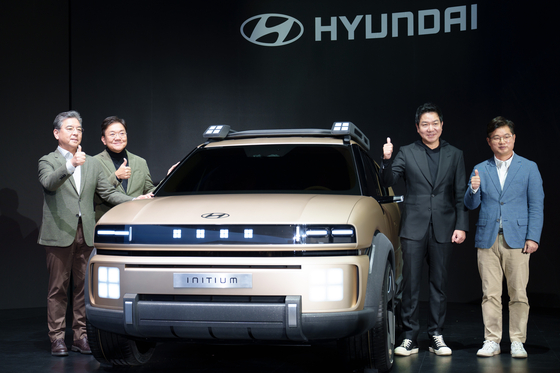 Hyundai Motor President and CEO, Chang Jae-hoon, left, and Lee Sang-yup, Executive Vice President and Head of Hyundai and Genesis Global Design Center, third from left, pose for the camera with the Initium hydrogen fuel cell electric vehicle concept on Thursday. [CHO YONG-JUN]