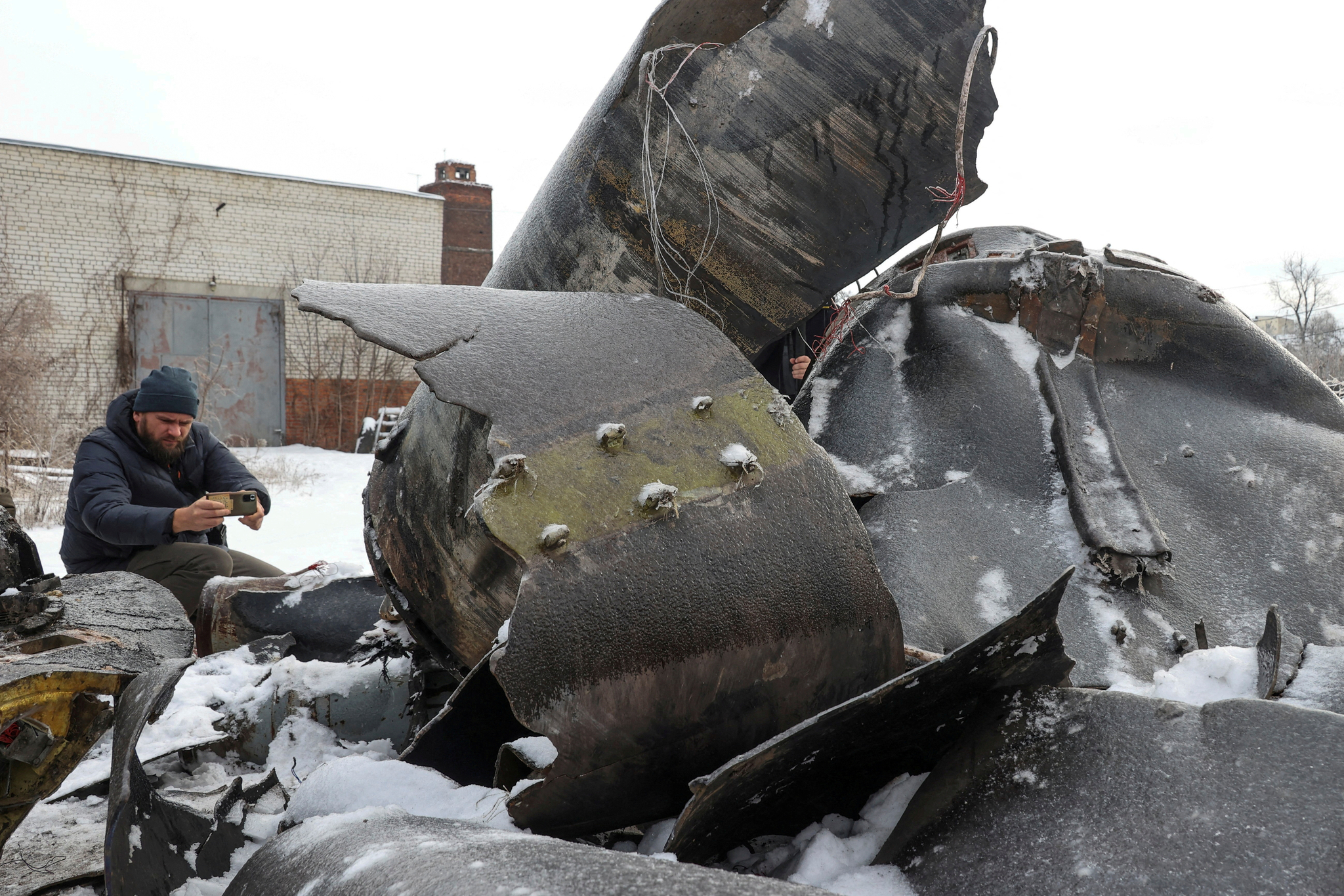 A man photographs parts of an unidentified missile, which Ukrainian authorities believe was made in North Korea and was used in a strike in Kharkiv earlier, amid Russia's attack on Ukraine on Jan. 6. [REUTERS/YONHAP] 