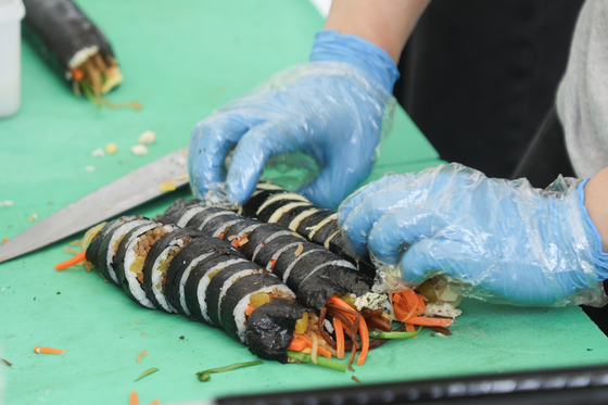 A vendor rolls gimbap (a seaweed rice roll) at the 2024 Jeonnam World Gimbap Festival in Yeouido, western Seoul, on Friday. [YONHAP]