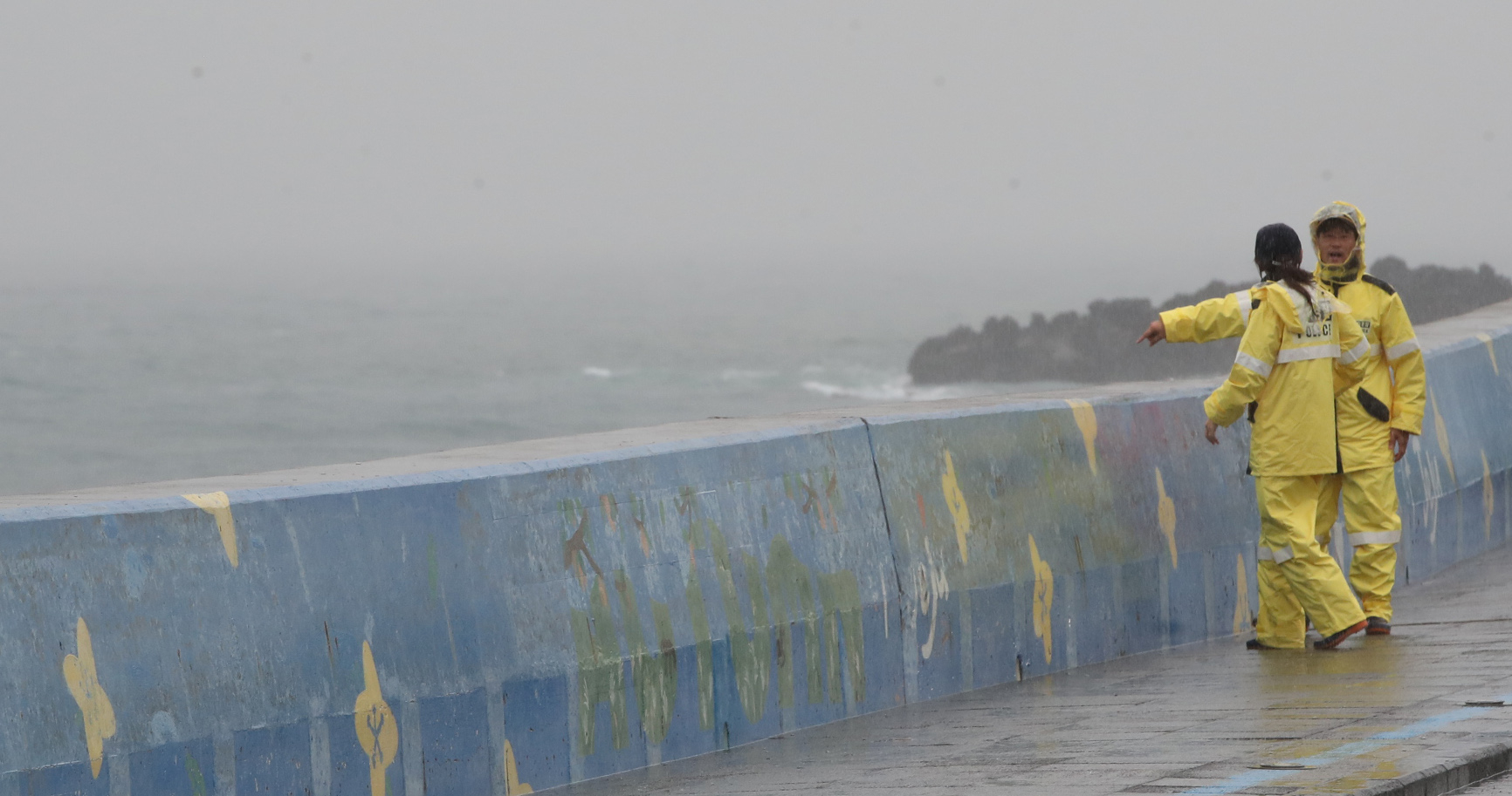Local police maintain security at a road in Jeju amid rainfall on Nov. 1 [YONHAP]  