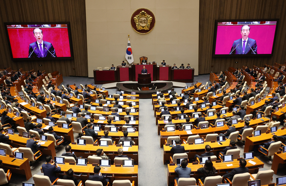 Prime Minister Han Duck-soo reads President Yoon Suk Yeol's budget speech during a plenary session at the National Assembly in Seoul on Monday. [YONHAP]