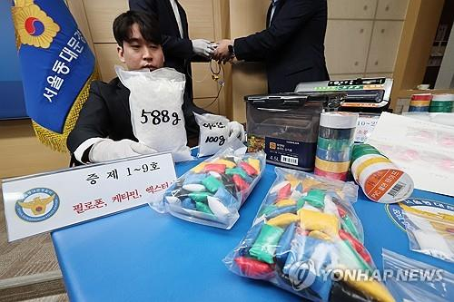 A police officer checks drugs seized from a suspected crime organization at a police station in Seoul on May 29, 2024. [YONHAP]