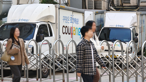 Coupang delivery trucks are parked at a parking lot in Seoul on Wednesday. [YONHAP]