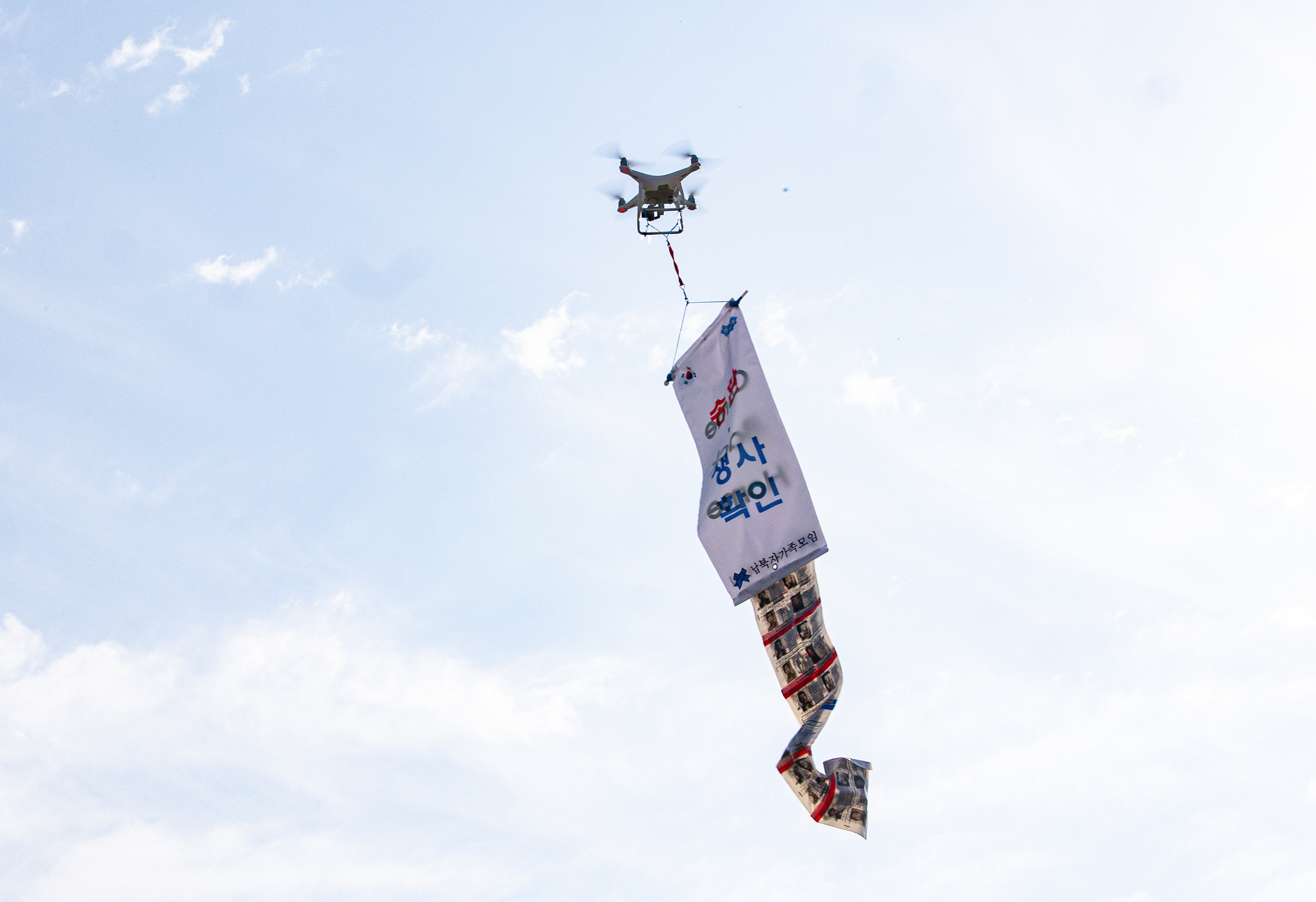 A drone carrying an anti-regime poster is seen flying in the sky over Paju, Gyeonggi, last Thursday. The drone was prepared by relatives of North Korean abductees. [NEWS1]