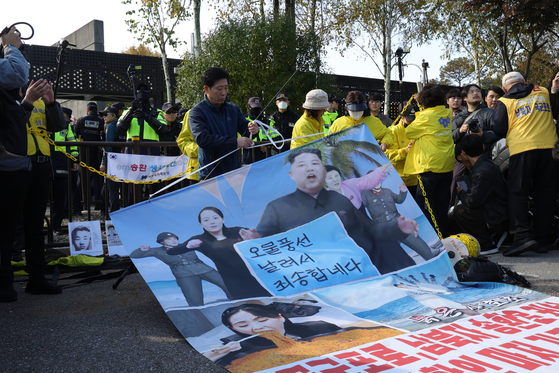 Park Sang-hak, head of Fighters for a Free North Korea, displays an anti-regime propaganda poster in Paju, northern Gyeonggi, last Thursday. [YONHAP]