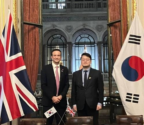 Rhee Dong-yeol, right, ambassador for international cyber affairs at South Korea's foreign ministry, and Andrew Whittaker, cyber director at Britain's Foreign Commonwealth and Development Office, pose for a photo during their talks in London on Wednesday. [YONHAP]