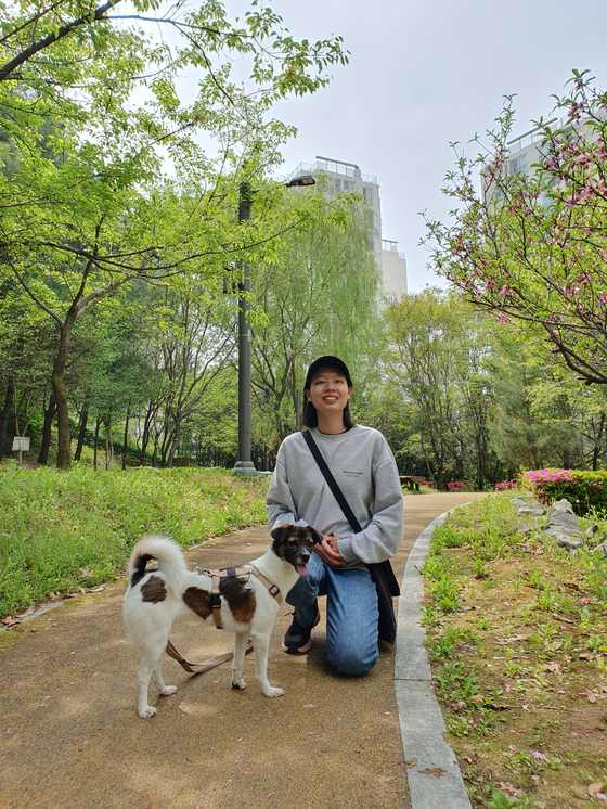 Jeong Hye-jin, who adopted Chorong from the Seoul Animal Care Center, poses with the dog. [JEONG HYE-JIN]