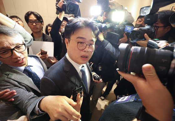 Lim Hyun-taek, chief of the Korean Medical Association, moves through a group of reporters after an emergency meeting of representatives in Yongsan District, central Seoul, on Sunday. [YONHAP]