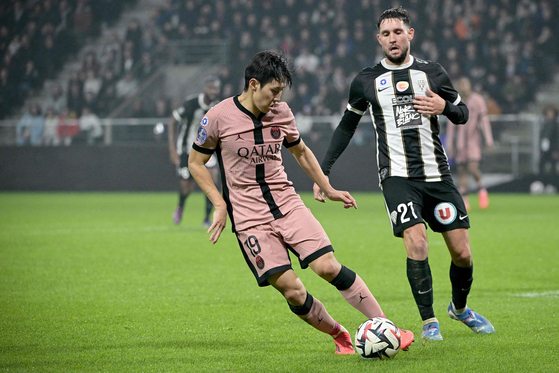 Paris Saint-Germain's Lee Kang-in controls the ball next to Angers' Jordan Lefort during a Ligue 1 match Stade Raymond Kopa in Angers, France, on Saturday.  [AFP/YONHAP]