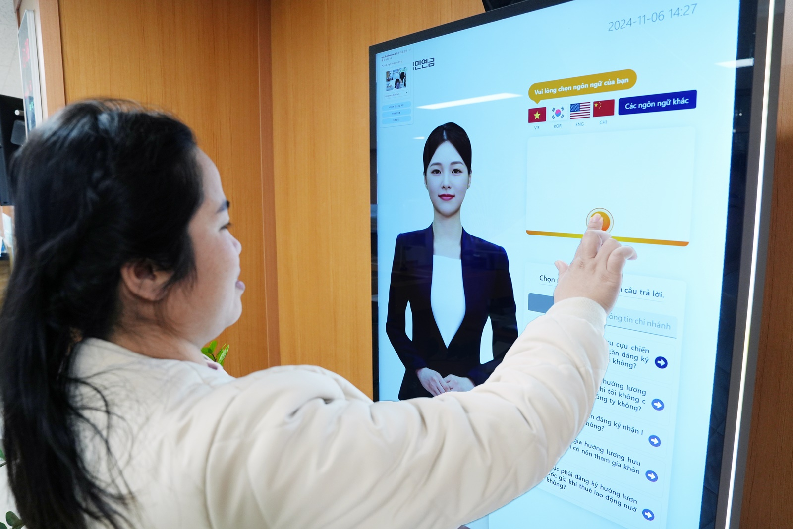 A visitor uses a kiosk with Youn-a. [NATIONAL PENSION SERVICE]