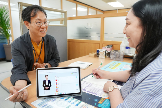 A public servant uses Youn-a's interpretation abilities in real-time to assist a customer. [NATIONAL PENSION SERVICE]