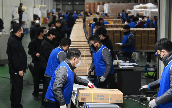Staffers prepare to load test booklets and answer sheets into transport vehicles at a printing facility in Sejong on Monday morning, three days before the 2025 College Scholastic Ability Test (CSAT), an exam that determines what colleges Korean students can enroll in. The Ministry of Education announced that the test materials will be distributed to 85 testing districts nationwide from Monday to Wednesday, with involvement from district officials, local education office representatives and ministry personnel, accompanied by police escorts during transportation. [JOINT PRESS CORPS]