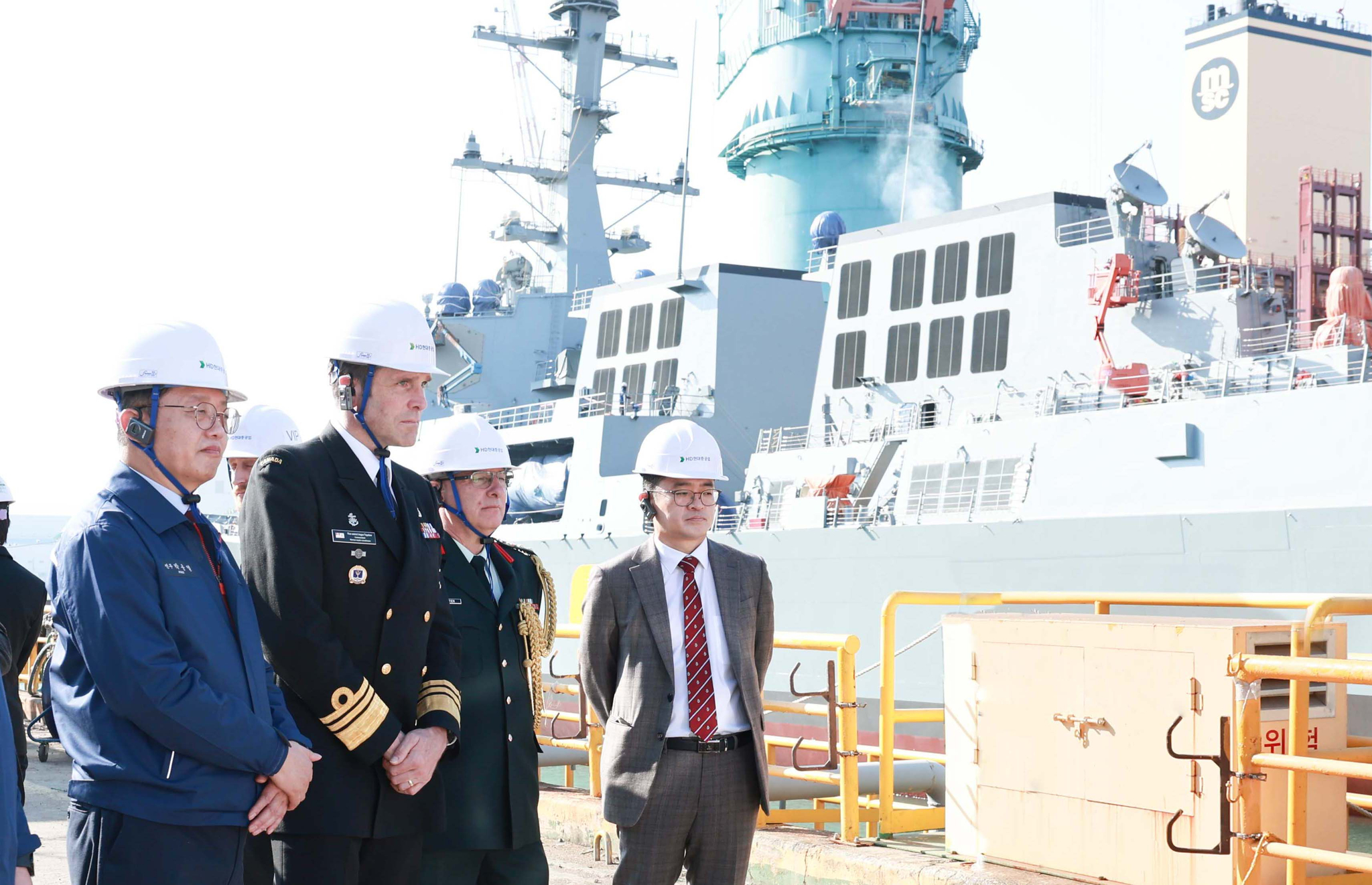 Second from left, Vice Admiral Angus Topshee, commander of the Royal Canadian Navy, is briefed about HD Hyundai Heavy Industries' Aegis destroyer, the King Jeongjo the Great, at the shipbuilding site in Ulsan on Tuesday. [HD HYUNDAI]