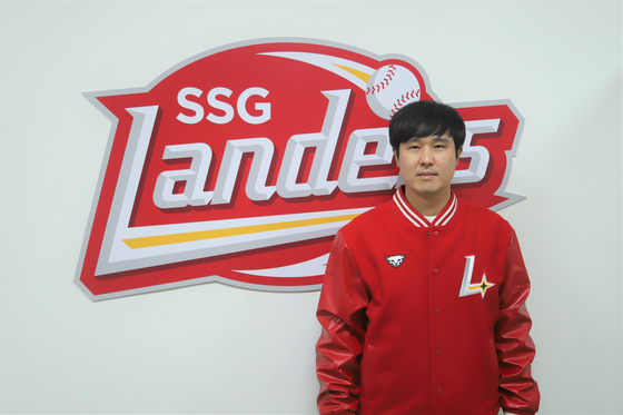 SSG Landers third baseman Choi Jeong poses in front of the team's logo at Incheon SSG Landers Field in Incheon after signing a free agent contract with the club on Nov. 6. [YONHAP]