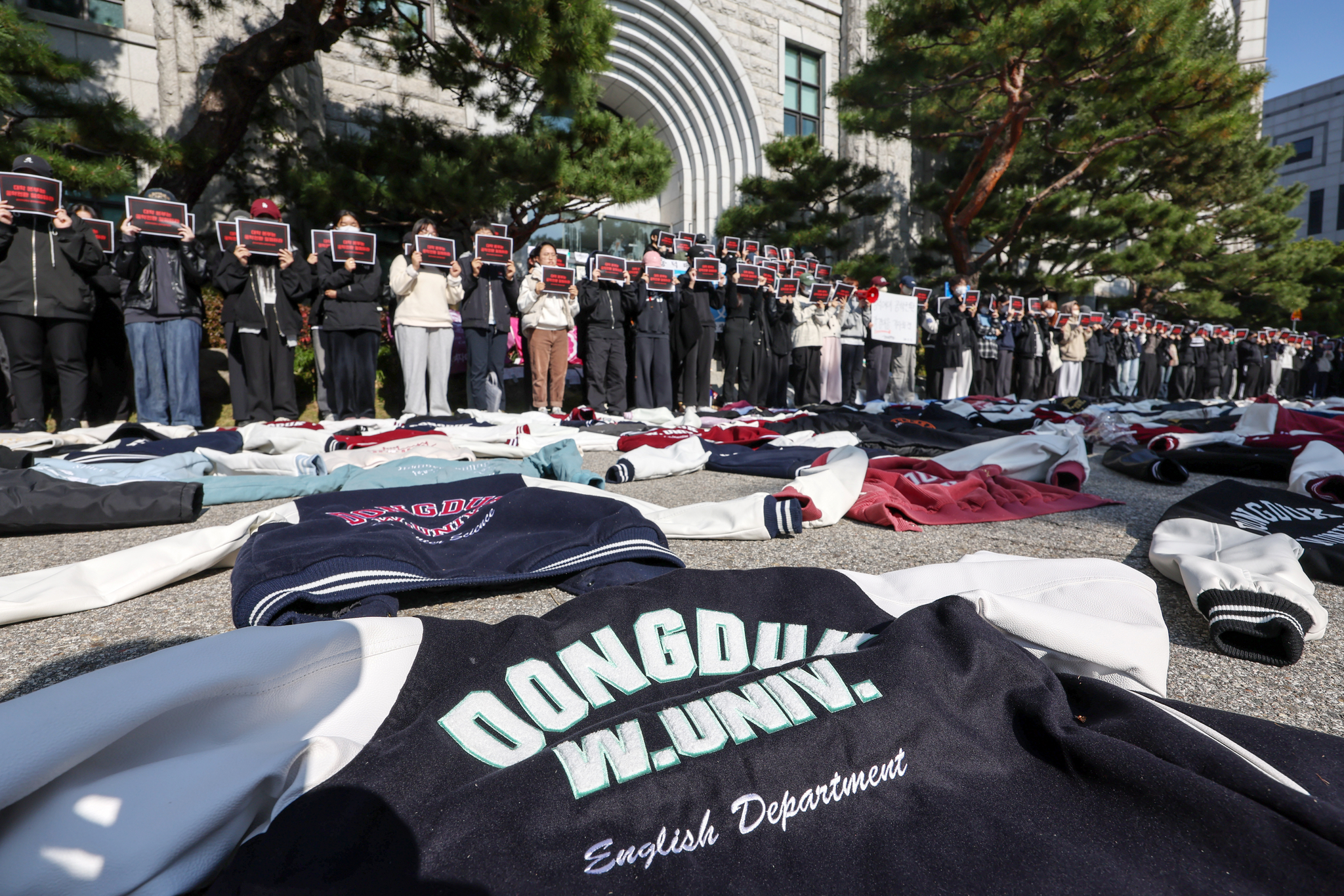 Dongduk Women's University students hold up signs urging the university to stop discussions about changing the university into a coeducational institution at the university campus in Seongbuk District, northern Seoul, on Tuesday. [NEWS1]