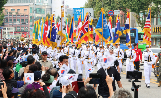 South Korean Navy officers and sailors hold the flags of the nations that fought under the United Nations Command during the 1950-53 Korean War as they march down a street in Jung District, central Incheon, as part of a parade to commemorate the success of Operation Chromite on Sept. 11, 2024. [YONHAP]