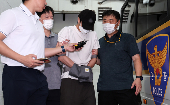The taekwondo instructor who suffocated a three-year-old child is being handed over to the prosecution from the Uijeongbu Police Precinct in Gyeonggi on July 19. [NEWS1]
