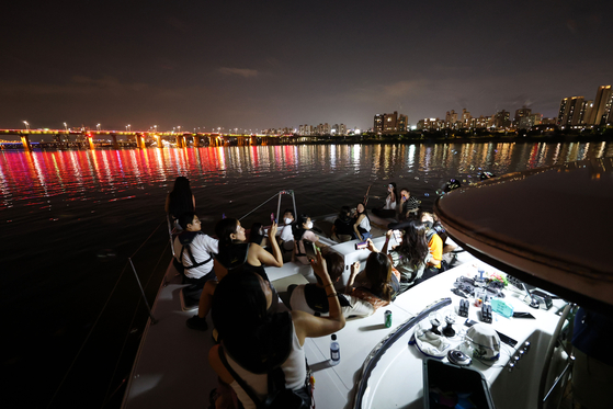 People enjoy a yacht ride near Sebitseom, a cultural complex on the Han River, at Banpo Hangang Park in southern Seoul on Feb. 29, 2022. [WOO SANG-JO] 