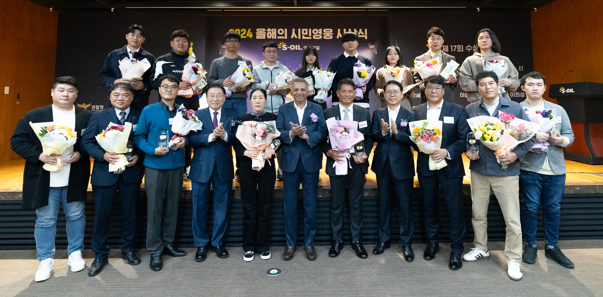 S-Oil CEO Anwar A. AL-Hejazi, sixth from left, and S-Oil President Ryu Yeol, fourth from right in the front row, pose with 17 citizen heroes at a ceremony at the oil refiner’s headquarters in Mapo District, western Seoul, on Thursday.[S-OIL]