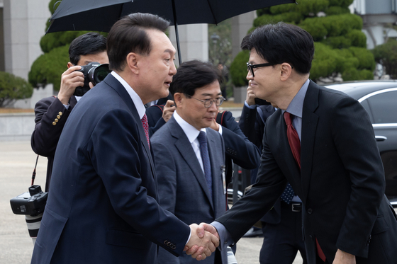 President Yoon Suk Yeol, left, shakes hands with Han Dong-hoon, leader of the ruling People Power Party, at Seoul Air Base in Seongnam, south of Seoul, on Thursday. [NEWS1]
