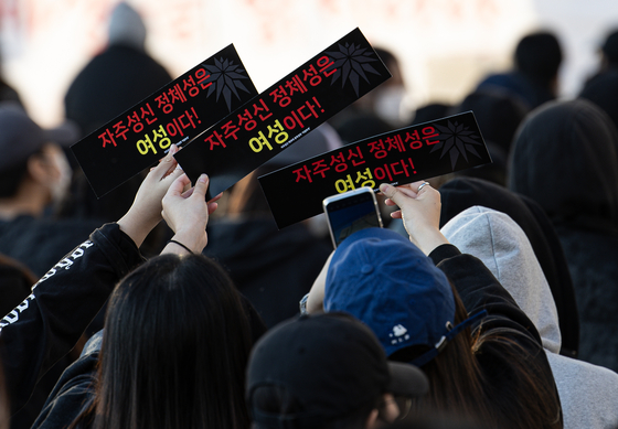 Students take photos with signs that read Sungshin Women's University's identity is women during a protest on Friday. [NEWS1]