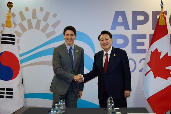 President Yoon Suk Yeol, right, shakes hands with Canadian Prime Minister Justin Trudeau during their summit held at the Lima Convention Center in Lima, Peru, on Nov. 15. [YONHAP]