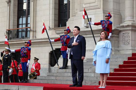 Korean President Yoon Suk Yeol, left, and Peruvian President Dina Boluarte, right, take part in an official welcome ceremony in Lima, Peru, ahead of their bilateral summit on Saturday. [JOINT PRESS CORPS]